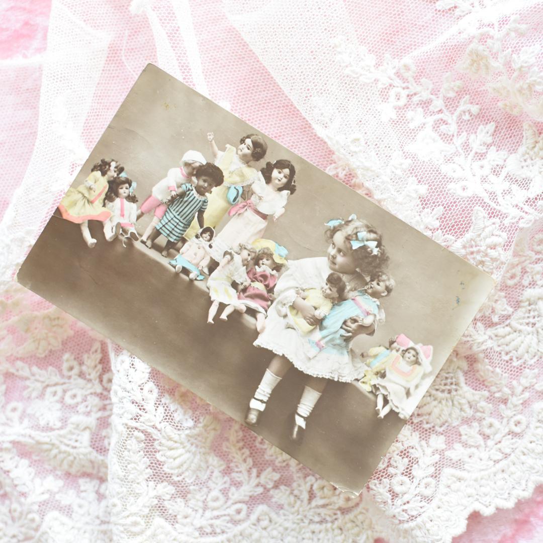 *アンティークポストカード　たくさんのお人形と愛らしい少女