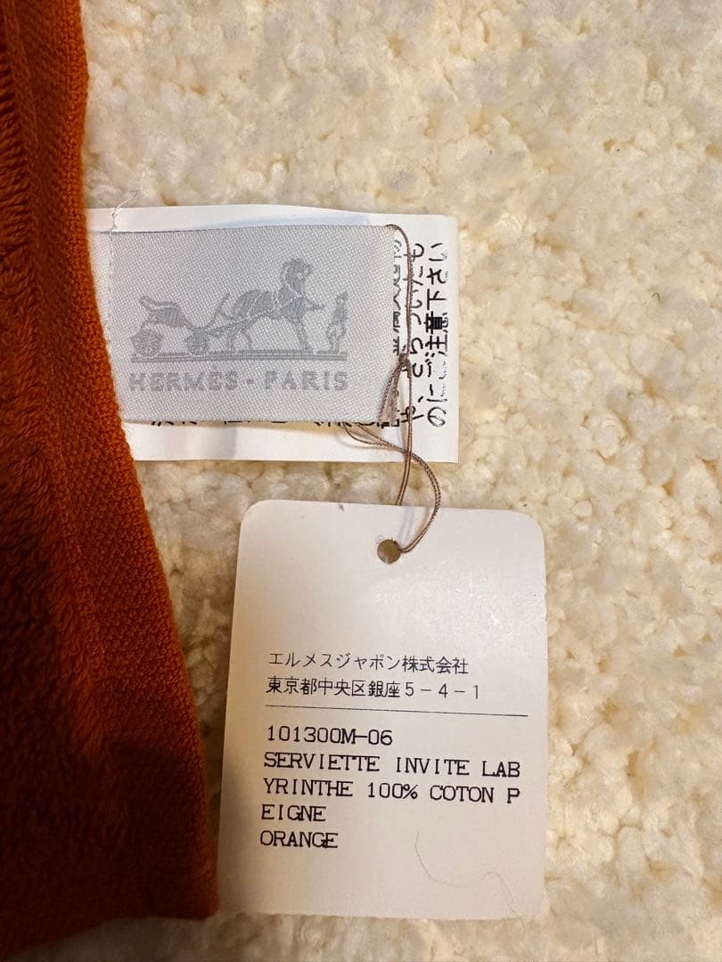 エルメス（HERMES）のHロゴ入りデザインのオレンジ色のコットン