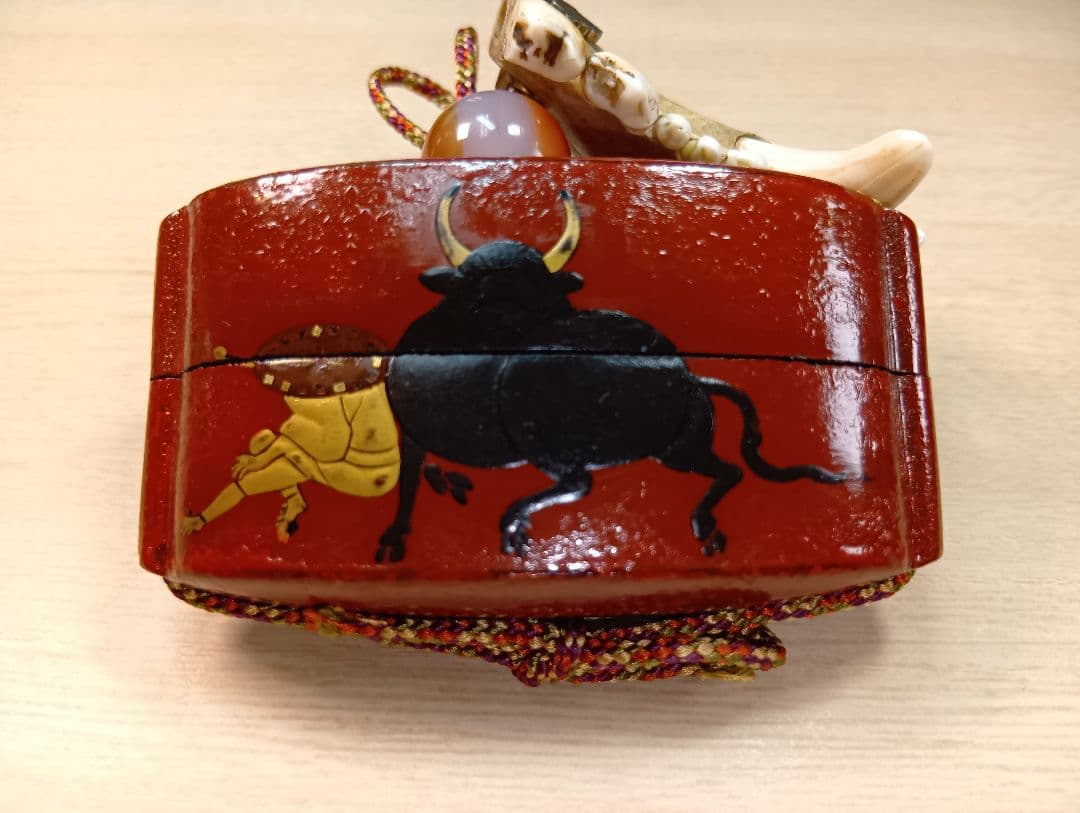 印籠朱塗り牛引き図／山岳信仰護符金工細工根付